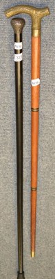 Lot 323 - A silver topped ebonised walking cane together with a brass handled flask cane