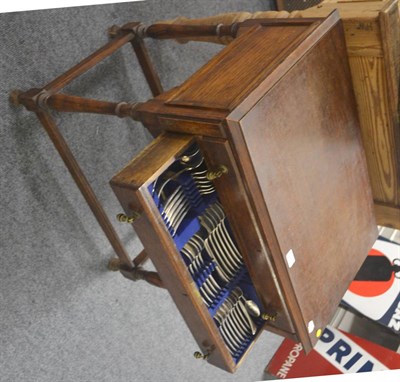 Lot 519 - A 1920's oak two drawer table containing mainly silver-plated flatware and silver teaspoons