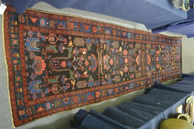 Lot 668 - Hamadan runner, Persian Kurdistan, the midnight blue field of stylised plants and flowers...