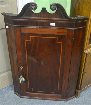 Lot 679 - A Georgian mahogany corner cupboard with swan neck pediment