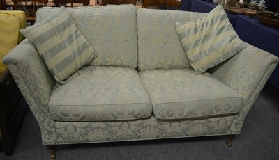 Lot 723 - A modern two-seater sofa upholstered in light green and floral brocade