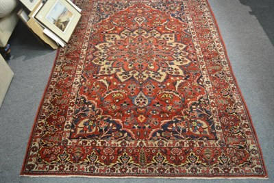 Lot 797 - Bakhtiari rug, West Persia, the tomato red ground of leafy vines around a flowerhead medallion...