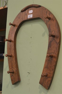 Lot 801 - An oak hunting crop rack in the form of a horseshoe