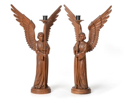 Lot 766 - A Pair of Carved Oak Altar Angels Candlesticks, adzed all over, both holding the rod for the...