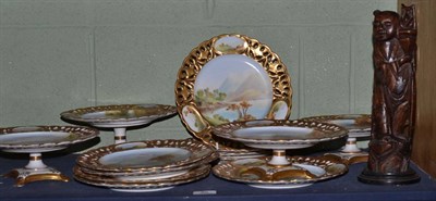 Lot 86 - A Staffordshire porcelain dessert service, painted with landscapes within gilt pierced borders