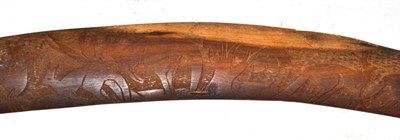 Lot 146 - An Australian Aborigine boomerang, one side lightly carved with kangaroos on a diapered field,...