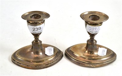 Lot 239 - A pair of filled silver dwarf candlesticks with nozzles, London 1911