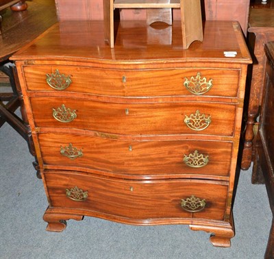 Lot 555 - A small serpentine dressing chest, the top drawer fitted with a brushing slide and compartments