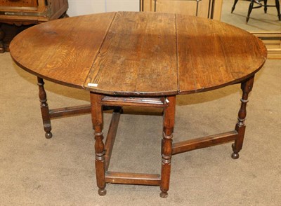 Lot 832 - An 18th Century Joined Oak Six-Seater Gateleg Table, with two rounded drop leaves to form an...