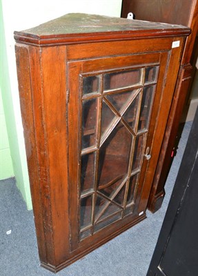 Lot 629 - An astragal glazed oak corner cabinet