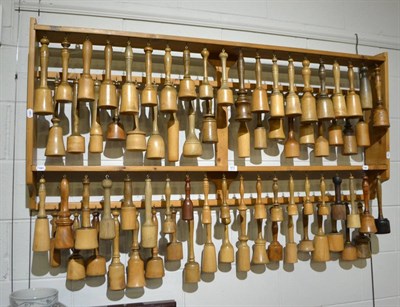 Lot 672 - Collection of seventy-seven turned wood potato mashers, on a pine rack