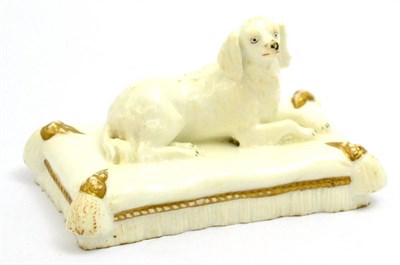 Lot 5248 - A 19th century English porcelain figure of a recumbent spaniel on a cushion