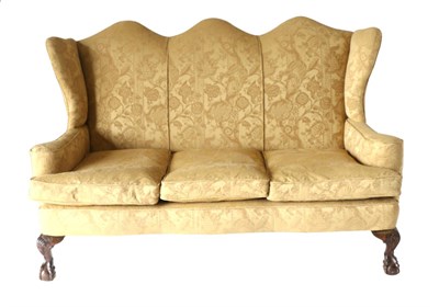 Lot 912 - A George I Style Wing-Back Three-Seater Sofa, upholstered in gold floral patterned cut fabric...