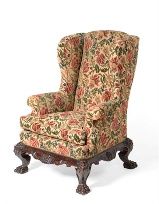 Lot 918 - A Queen Anne Style Wing-Back Armchair, upholstered in floral close-nailed wool fabric, with rounded