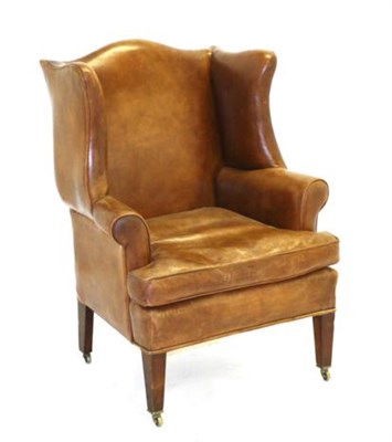 Lot 919 - A 19th Century Brown Leather Wing-Back Chair, in George III style, with flared sides above...