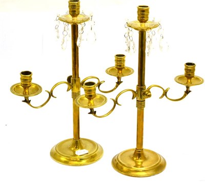 Lot 5493 - A pair of ecclesiastical adjustable brass candlesticks each with a lustre drop drip tray