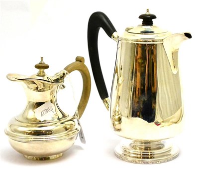 Lot 5534 - A silver hot water jug, London 1914 and a silver hot water jug, Sheffield 1912