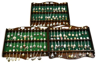 Lot 5606 - Three oak spoon racks containing a collection of silver and plated collector spoons (100+)