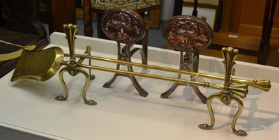 Lot 6027 - A pair of copper Arts & Craft fire dogs, a brass pair and a brass poker and shovel (6)