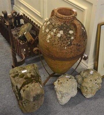 Lot 6138 - A sandstone head, two other heads and a wine jar on stand (4)