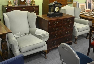 Lot 6309 - An oak framed wing armchair with stretcher base and another similar on carved legs