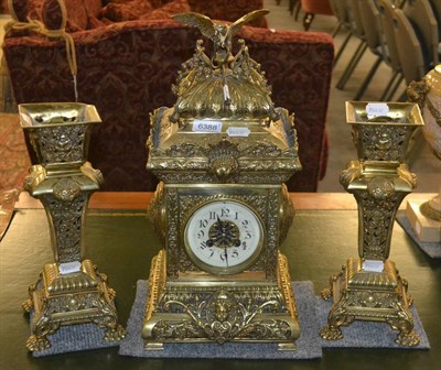 Lot 6388 - A German brass striking mantel clock with garniture