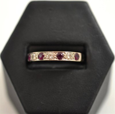 Lot 83 - 18ct white gold ruby and diamond half hoop eternity ring