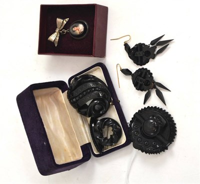 Lot 98 - A jet brooch with matching pair of earrings, three jet brooches and another with portrait insert