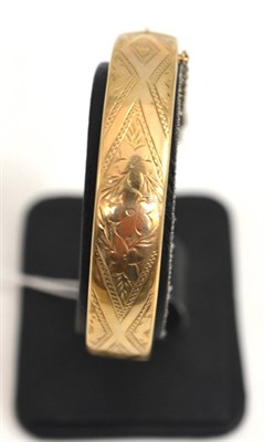 Lot 99 - A 9ct gold engraved hinged bangle