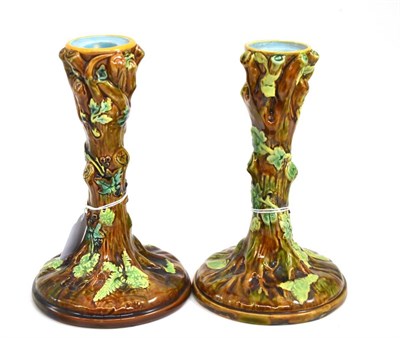 Lot 106 - A pair of George Jones majolica candlesticks modelled as tree trunks (one with crescent mark,...