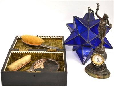 Lot 174 - Ebonised hinged box with fabric lining, silver brush set, figural timepiece, blue leaded glass...