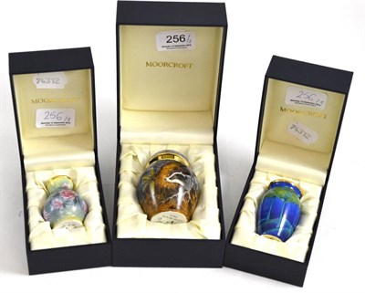 Lot 256 - Two modern Moorcroft enamel vases (boxed) and a modern Moorcroft enamel ginger jar and cover...