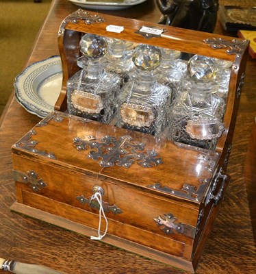 Lot 374 - An oak tantalus with three cut glass decanters and stoppers