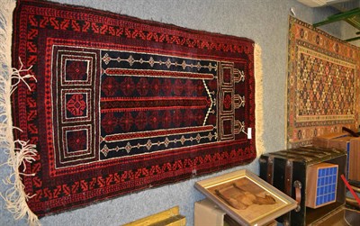 Lot 1007 - Balouch prayer rug, West Afghanistan, the indigo field beneath a stepped Mihrab enclosed by...