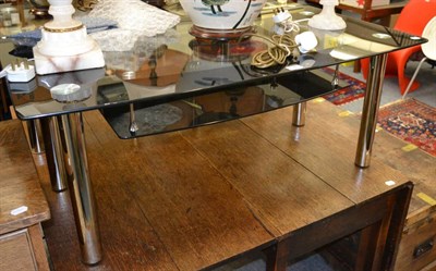 Lot 1048 - Modern black and clear glass coffee table on tubular chrome supports