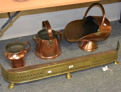 Lot 1064 - Engraved brass fender, copper coal scuttle and two jugs