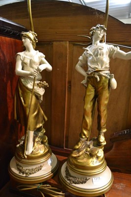 Lot 1315 - Two cream and gilt decorated figural table lamps with shades