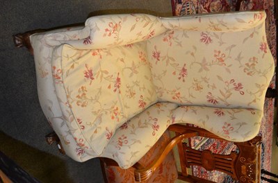 Lot 1399 - Walnut wing back chair on claw feet with modern upholstery