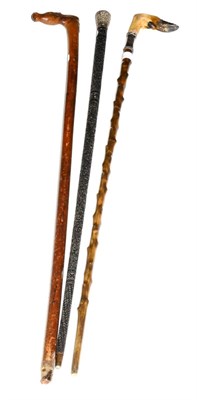 Lot 180 - Three sticks, one with carving throughout and mounted with a white metal scroll (3)