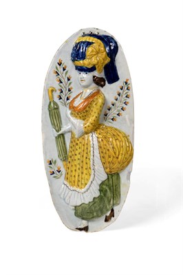 Lot 165 - A Prattware Plaque, circa 1790, modelled and painted with a fashionable lady holding an umbrella on