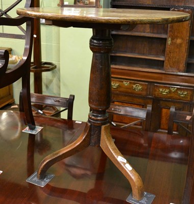 Lot 743 - George III oak circular topped tilt top tripod table