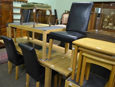 Lot 821 - A modern light oak extending dining table, a set of six black leather upholstered dining chairs and