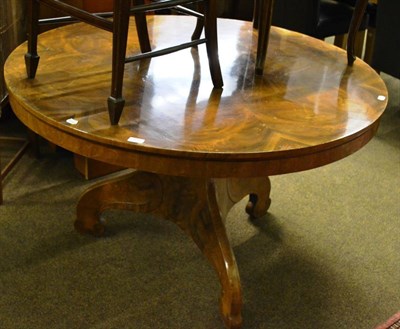 Lot 829 - A Continental walnut loo table, the circular radially veneered top raised on a three-sided...