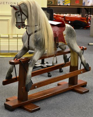 Lot 866 - Collinson dapple grey rocking horse on treadle base, complete with leather tack