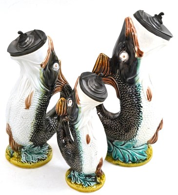 Lot 185 - A set of three Staffordshire fish jugs with pewter mouths