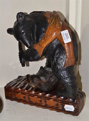 Lot 265 - A Black Forest carving of a bear with two fish swung over its back and a Black Forest match...