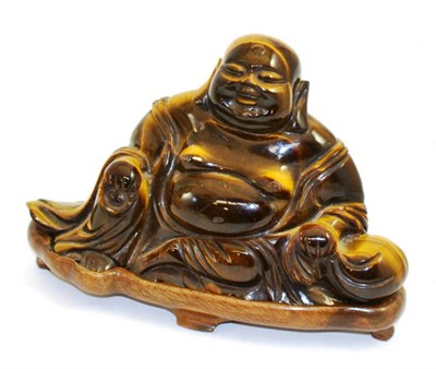 Lot 391 - A Tiger's eye Buddha on wood stand