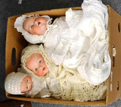 Lot 1137 - Four Armand Marseille baby dolls (two are seconds), all fully clothed in cotton gowns with bonnets