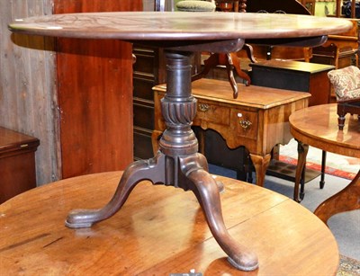 Lot 1310 - A George III mahogany tilt top tea table with a one piece top and turned baluster column