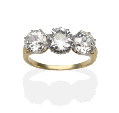 Lot 292 - A Diamond Three Stone Ring, graduated old cut diamonds in white claw settings, to yellow scroll...